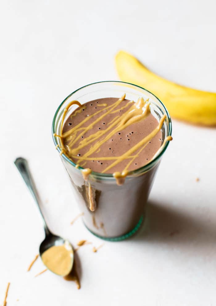 smoothie in a glass with a nut butter drizzle on top