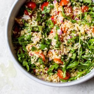 salad in a bowl with grains and tomato