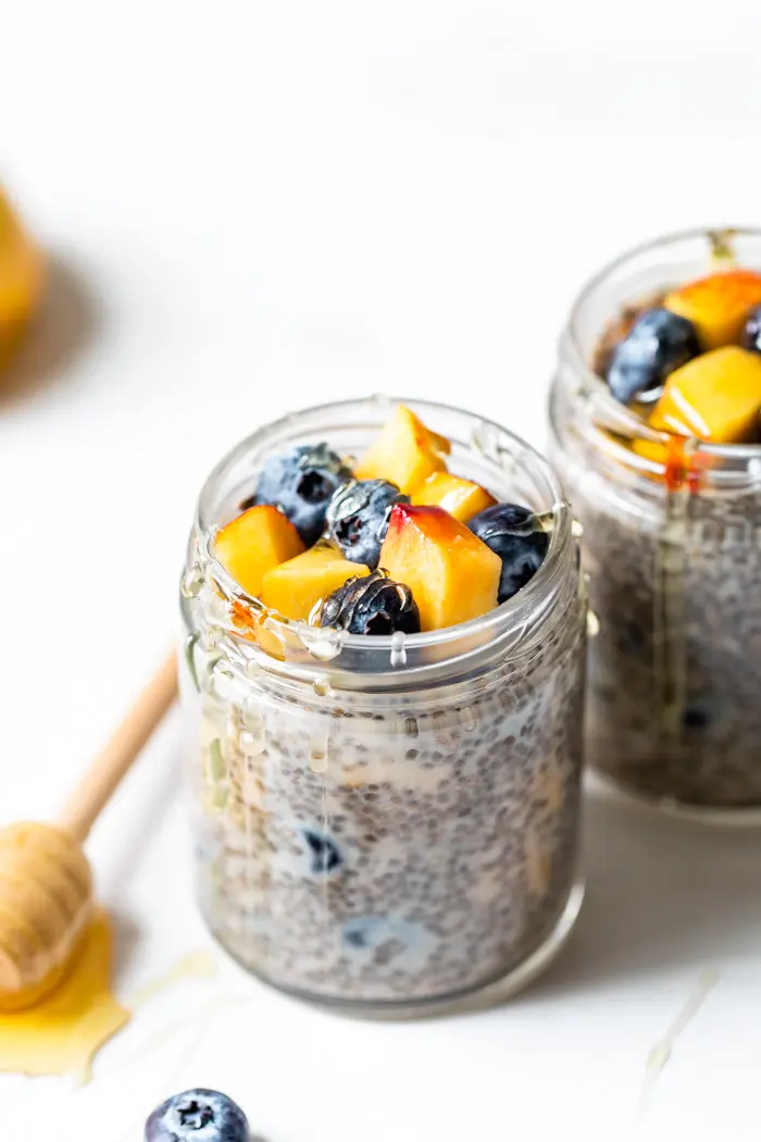 jar of chia seeds and milk topped with nectarine and fresh blueberries