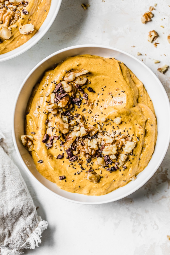 A pumpkin smoothie bowl topped with walnuts, chia seeds and cacao nibs