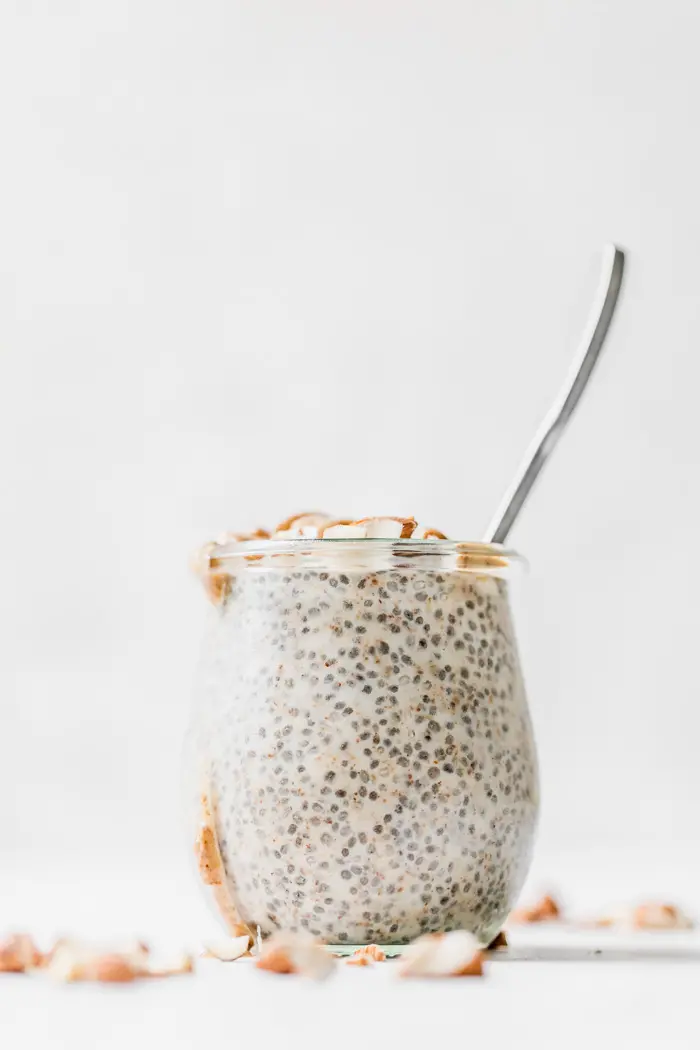 A jar of chia pudding with a spoon in it