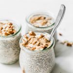 Three jars of chia pudding topped with almonds and almond butter
