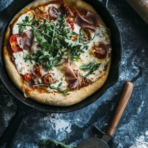 A delicious skillet pizza topped with fresh mozzarella, prosciutto and arugula | thealmondeater.com