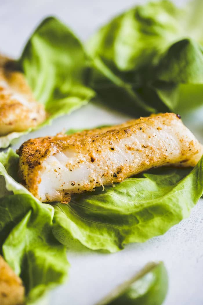fried cod on top of lettuce