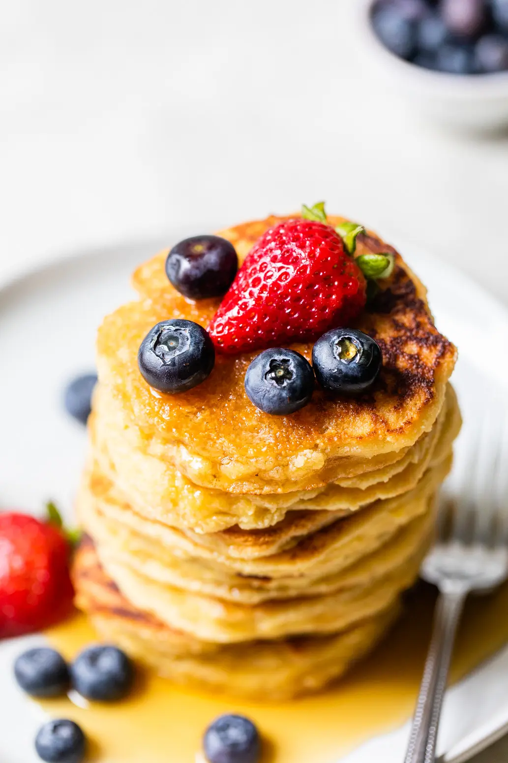 stack of pancakes topped with fruit