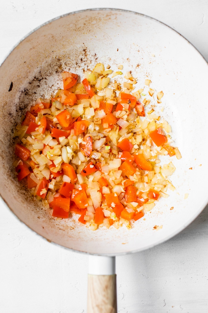 onion and diced peppers in a skillet