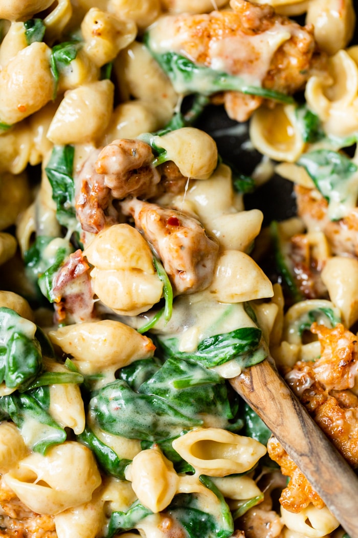 close up of pasta with sausage and spinach