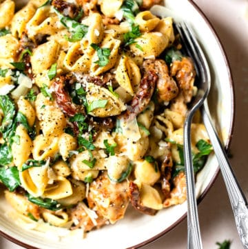 a bowl of pasta with sausage and spinach