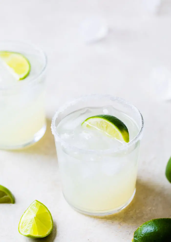 glass filled with ice lime juice and a lime wedge