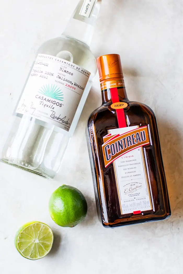 bottle of tequila, cointreau and two limes