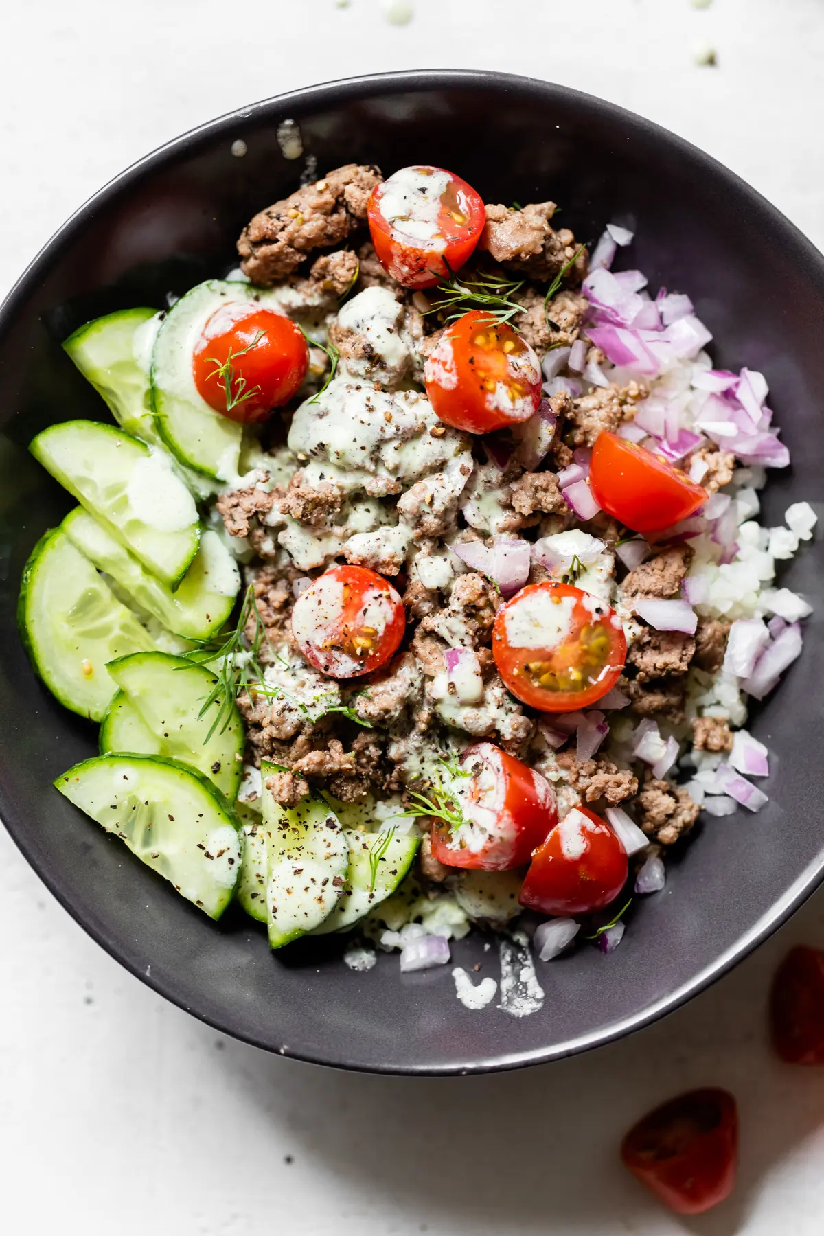 bowl with cucumber, tomatoes, onion, and ground lamb