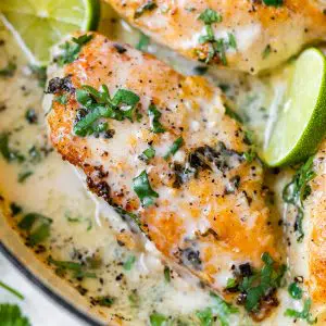 chicken in a skillet with lime wedges