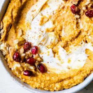 a bowl of hummus topped with nuts