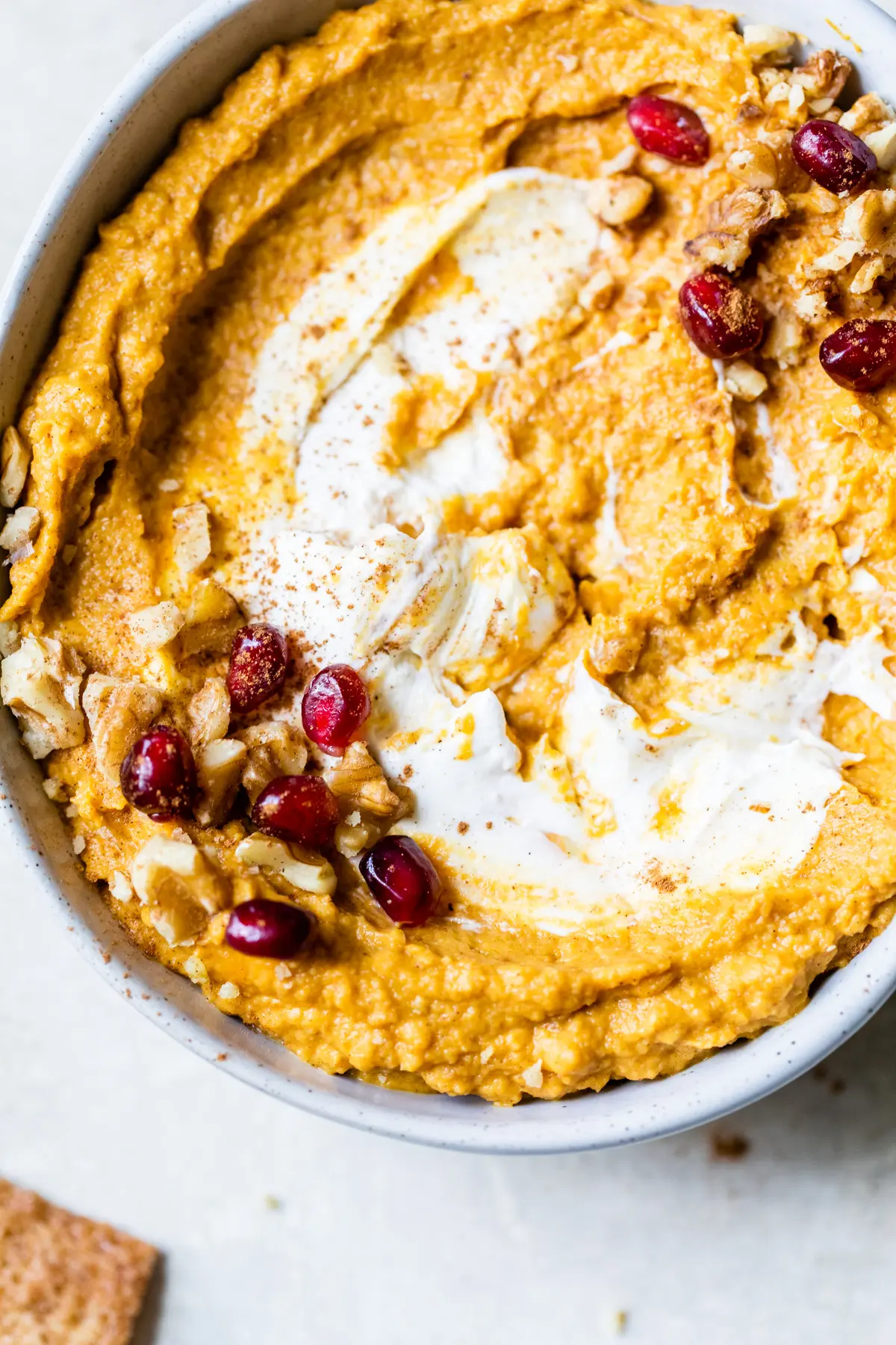 a bowl of hummus topped with nuts