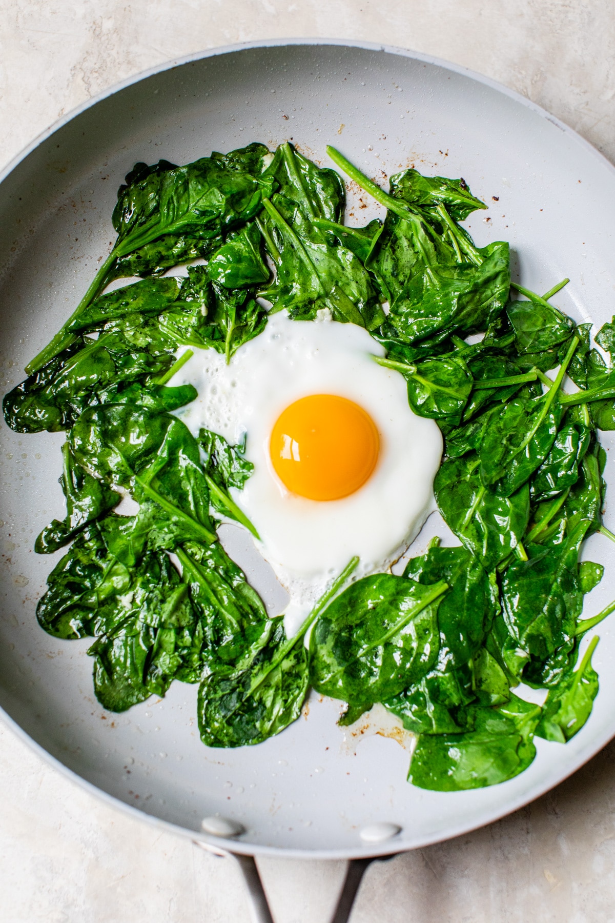 spinach and an egg in a skillet