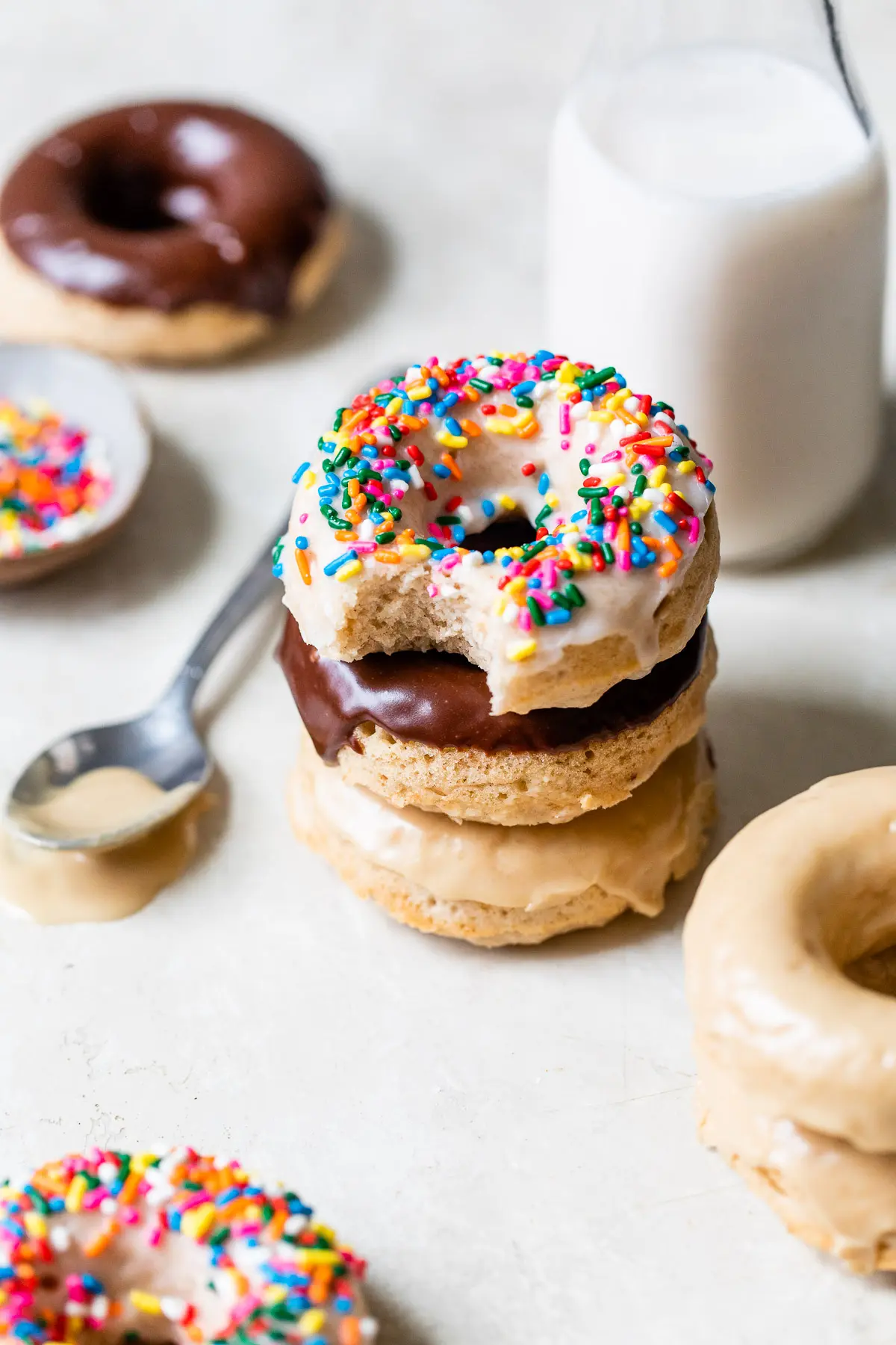 a stack of donuts beside a glass of milk