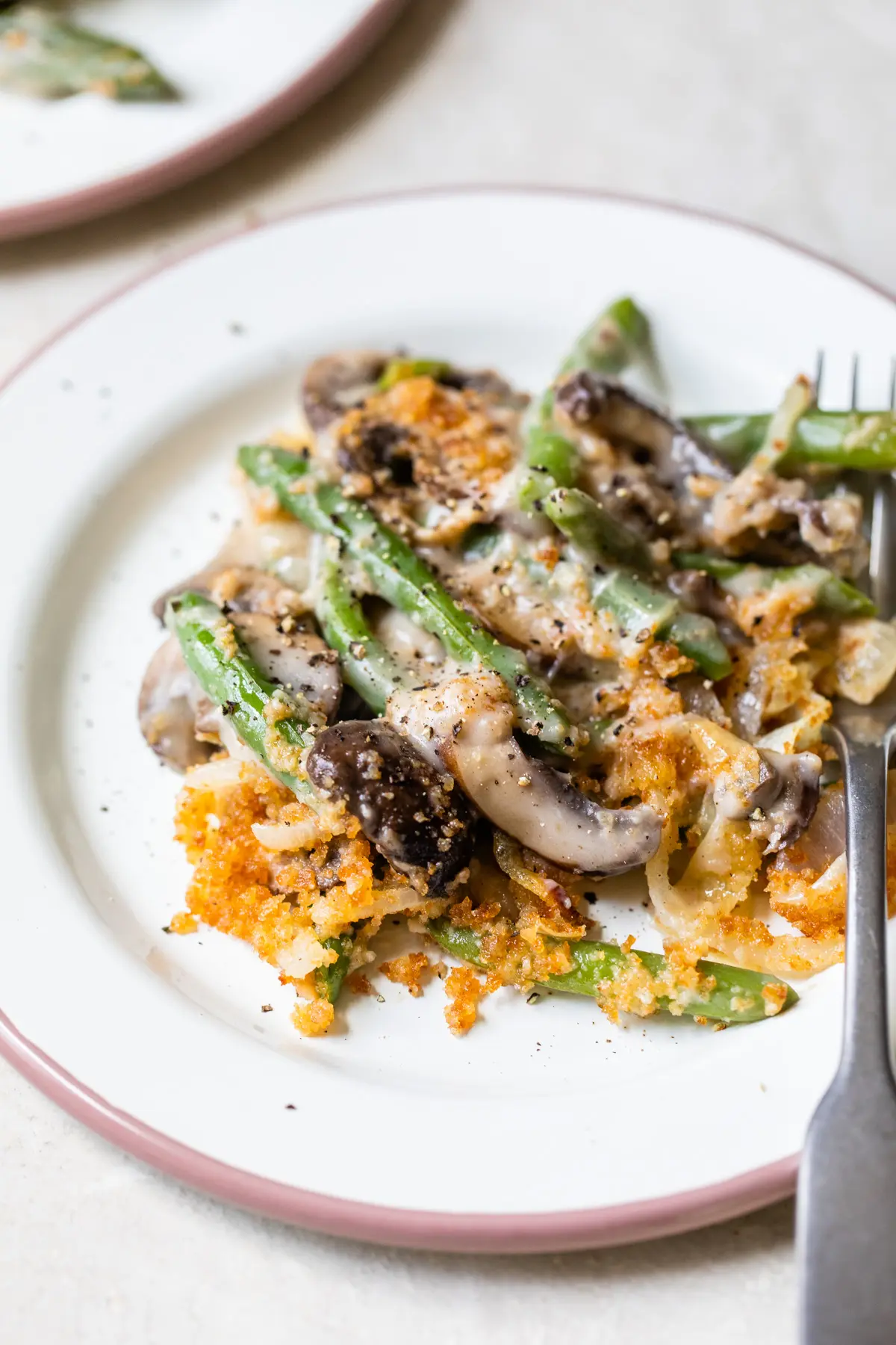 green beans, mushrooms and crispy onions on a plate with a fork