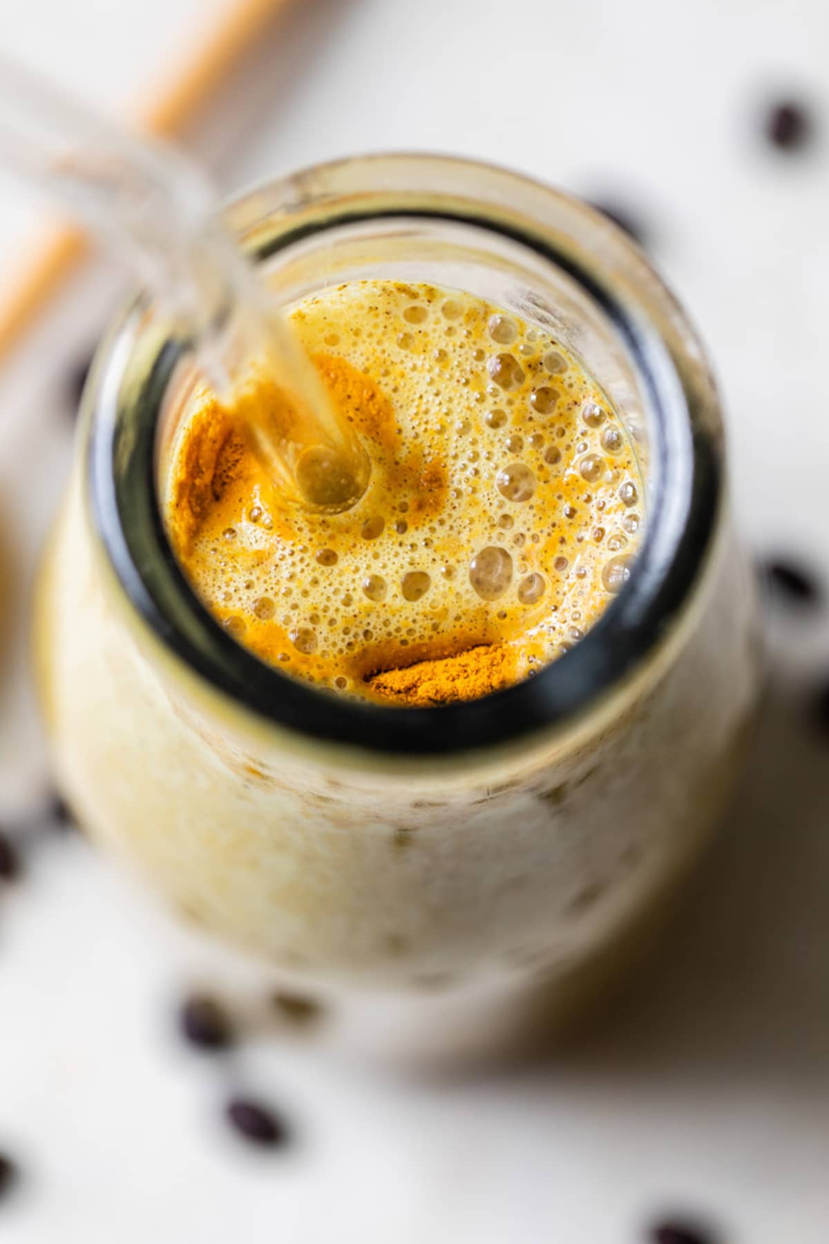 overhead photo of a yellow smoothie in a glass jar