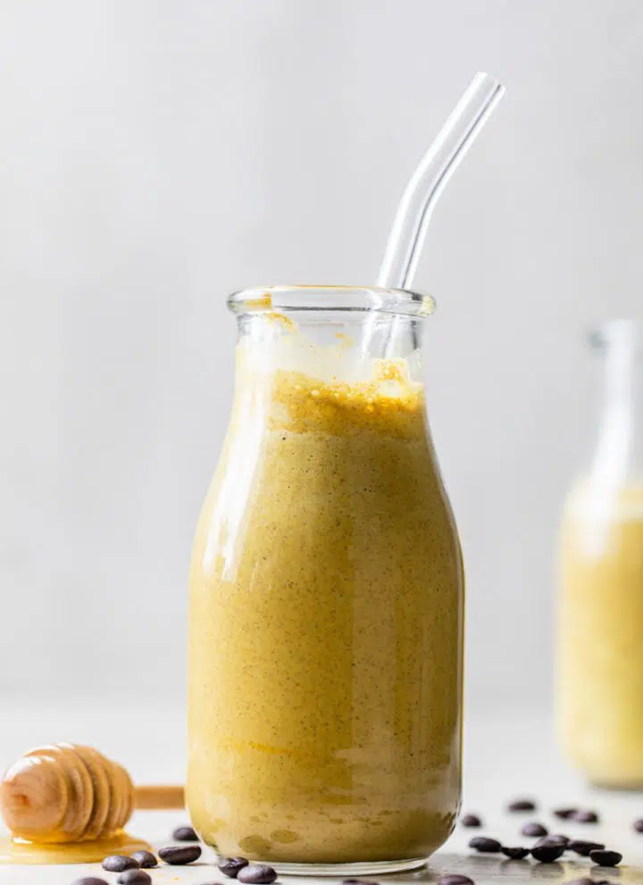 glass jar filled with a yellow-colored smoothie