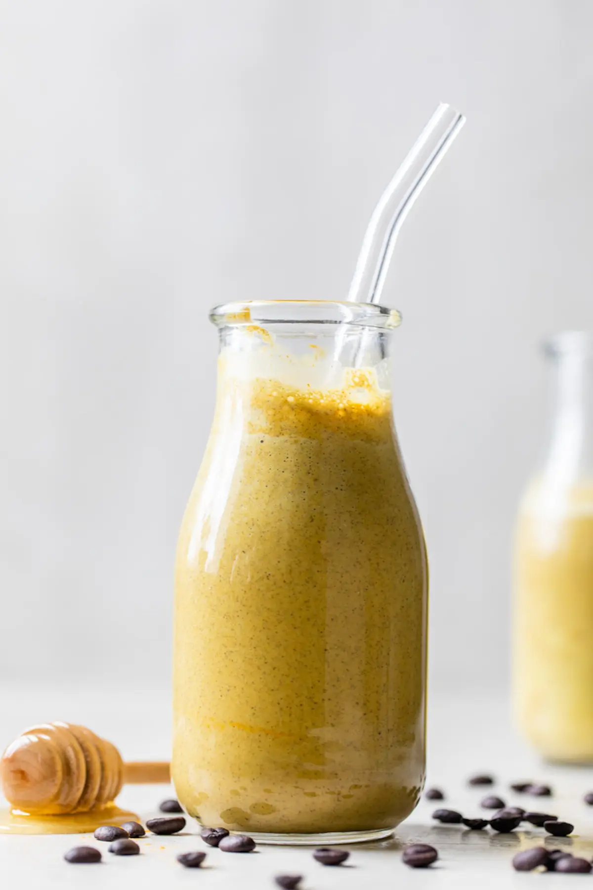 glass jar filled with a yellow-colored smoothie