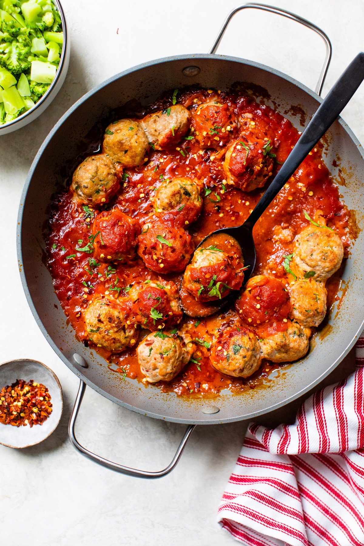 skillet with meatballs and broccoli beside it