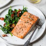 cooked salmon fillet on a plate with spinach