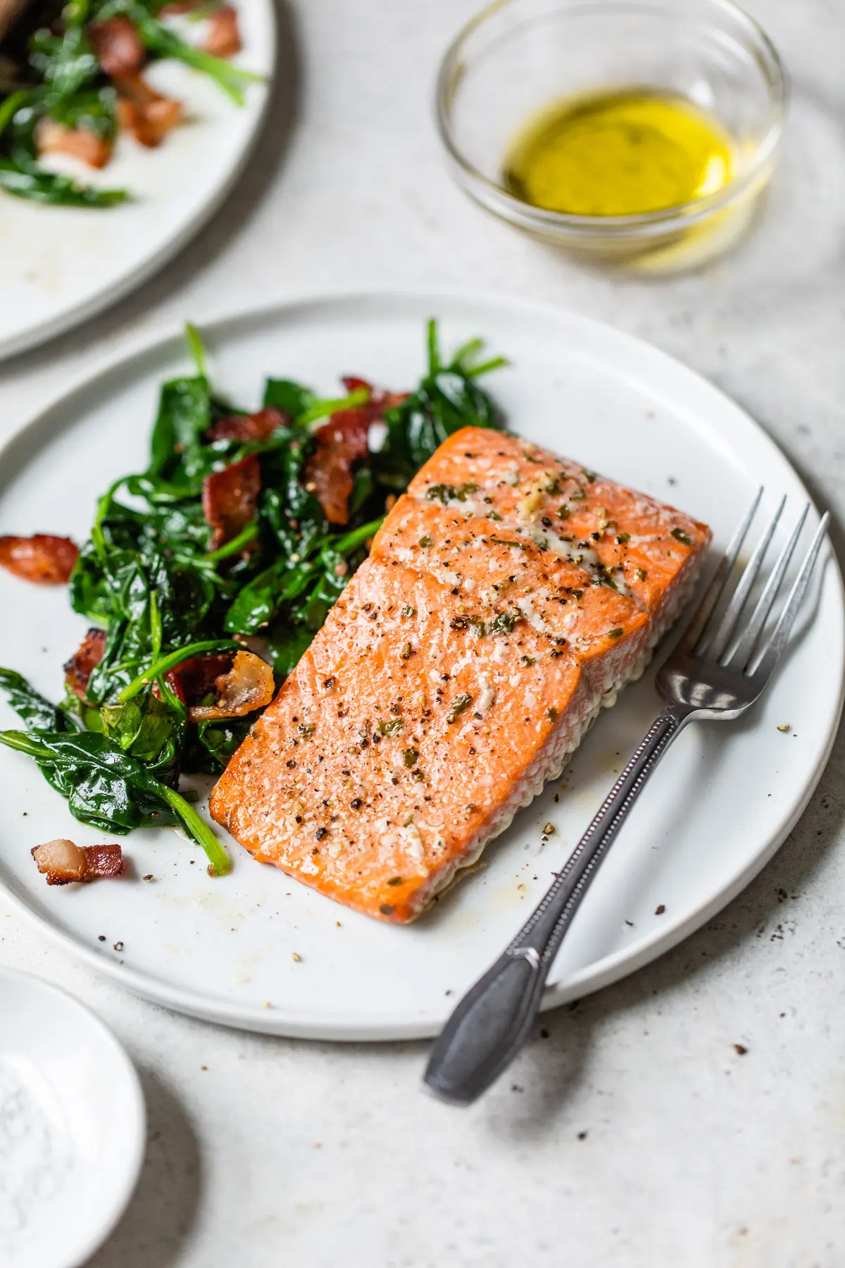 cooked salmon fillet on a plate with spinach