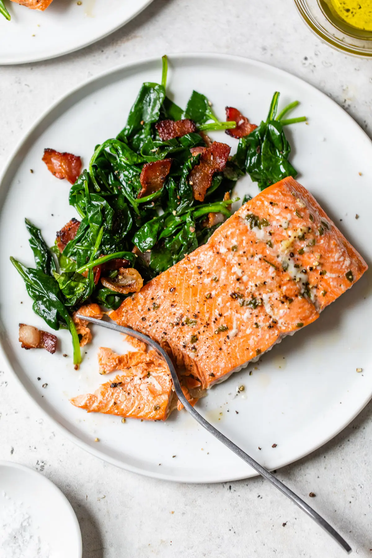 cooked salmon and spinach on a plate