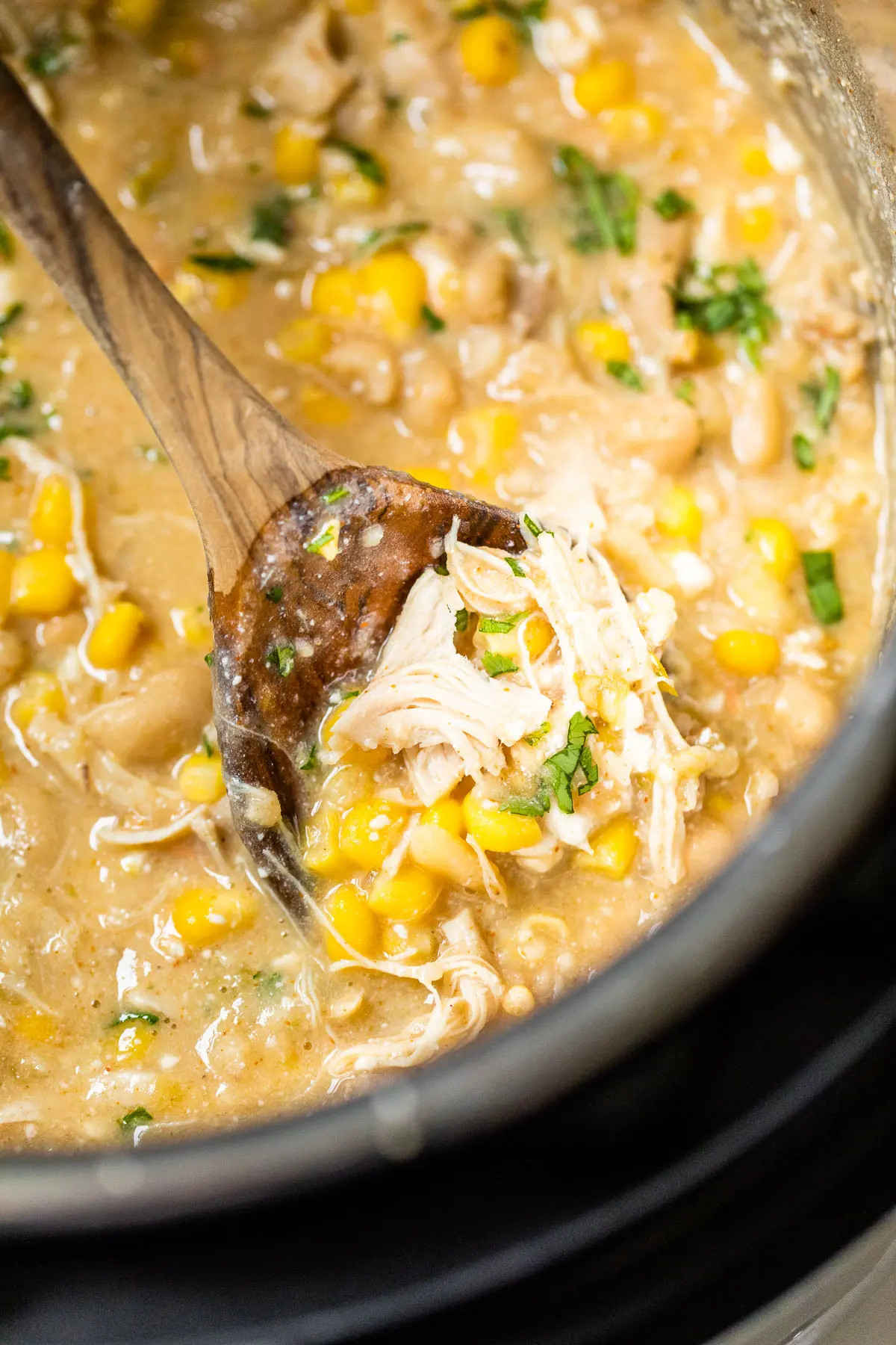 cooked shredded chicken, corn and broth in a pressure cooker