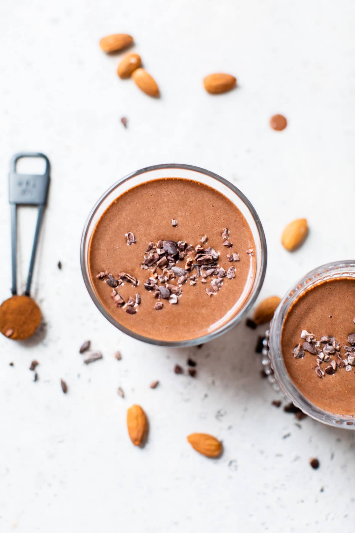 overhead shot of a chocolate smoothie topped with cacao nibs