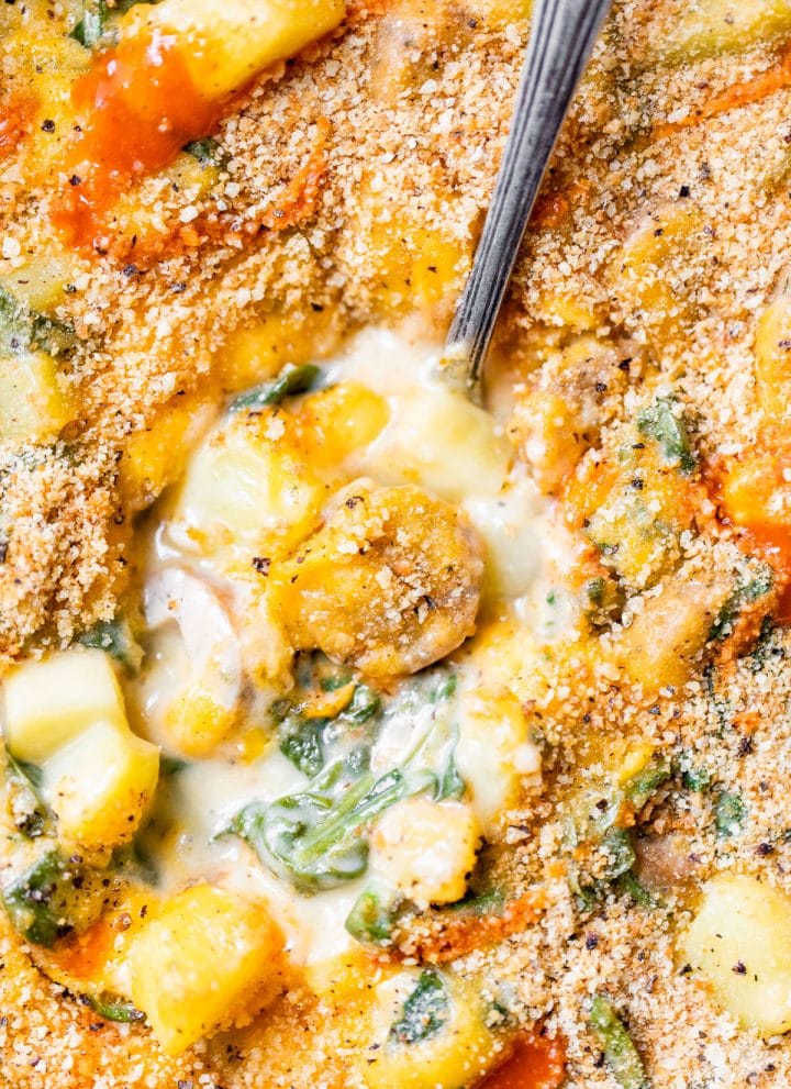 creamy cheese sauce with sausage, potatoes, spinach, and breadcrumbs