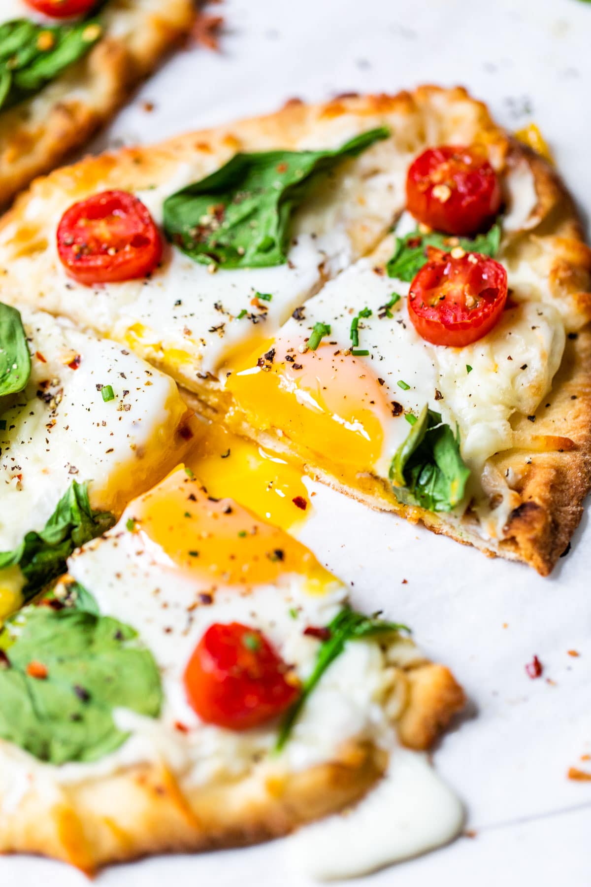 sliced naan pizza with an egg and runny egg yolk
