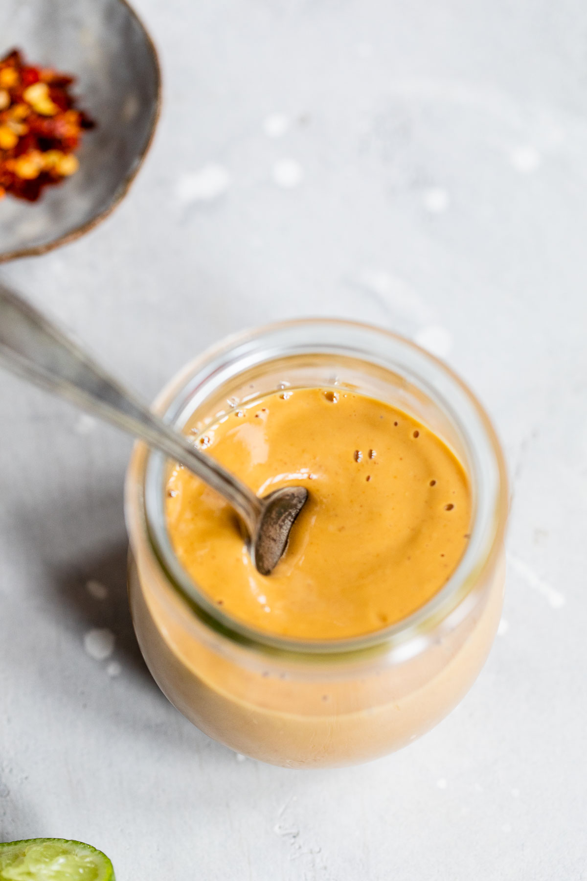 orange sauce in a jar with a spoon