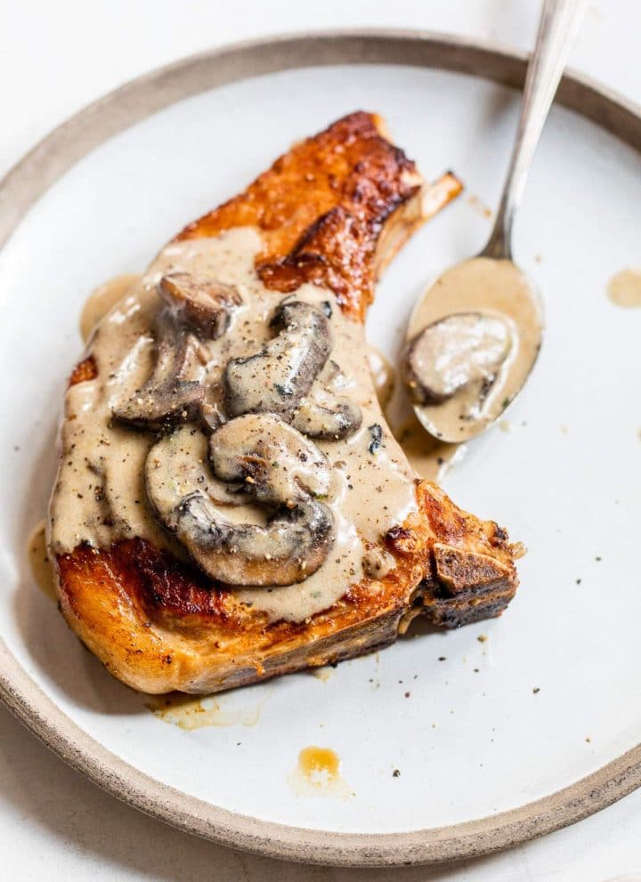 bone-in porch chop on a plate with mushroom sauce