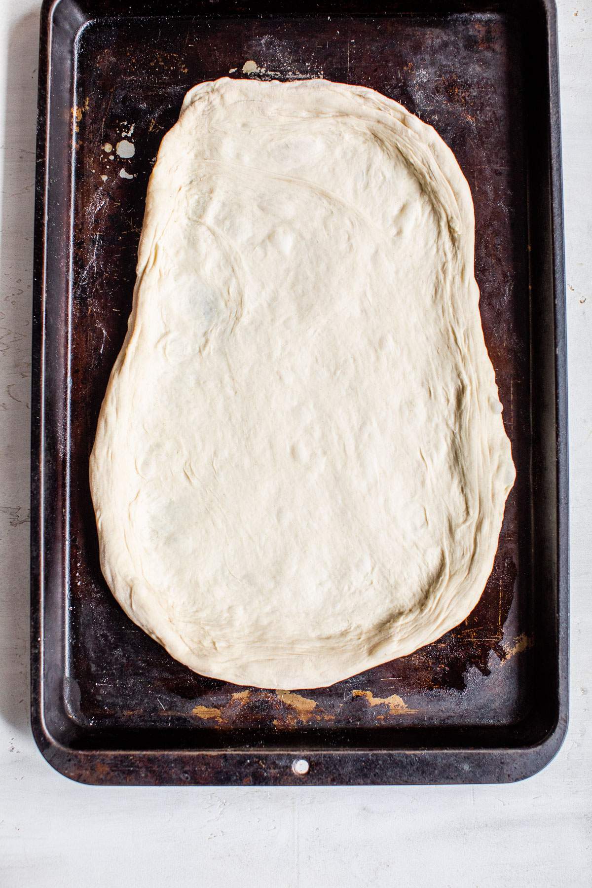 pizza dough on a baking sheet