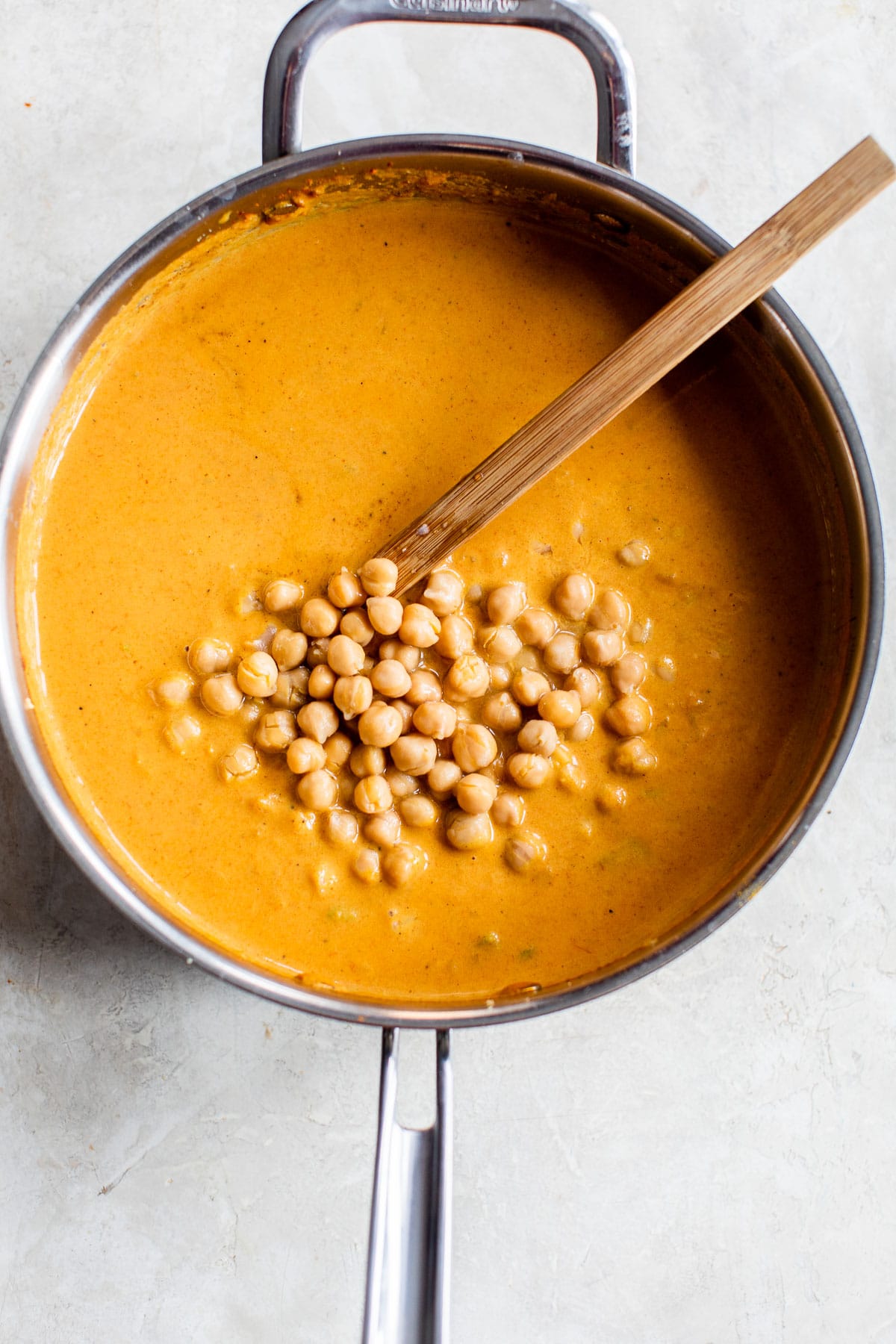 chickpeas in a skillet with orange-colored sauce
