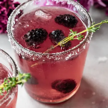 a cocktail with fresh blackberries in it