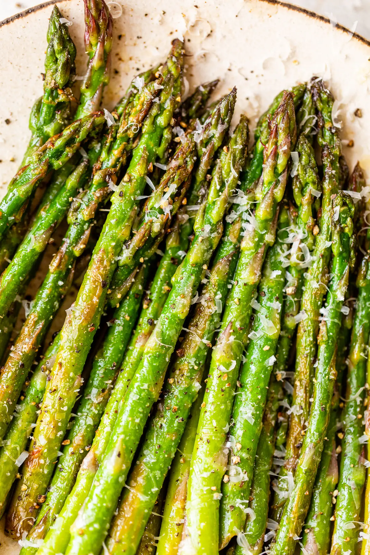 close up of asparagus sprinkled with shredded parmesan cheese