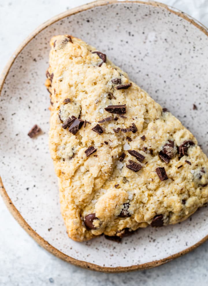 a scone on a plate topped with chopped chocolate