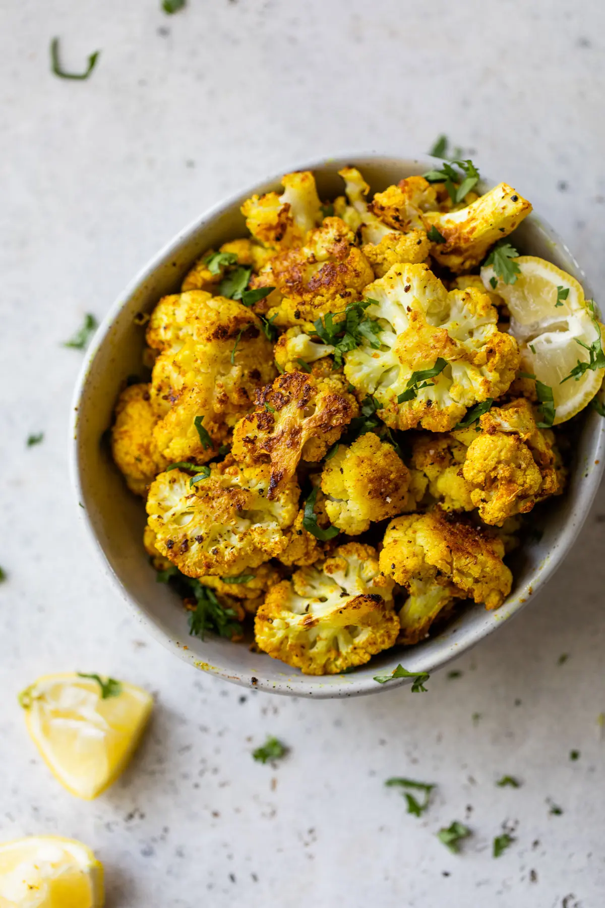 roasted cauliflower in a small bowl topped with chopped parsley
