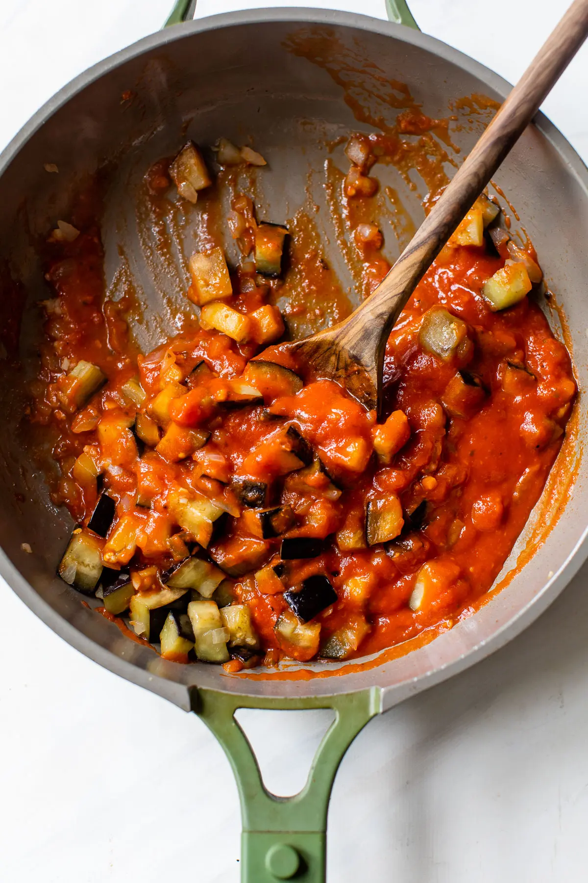 cooked diced eggplant in a skillet with marinara sauce