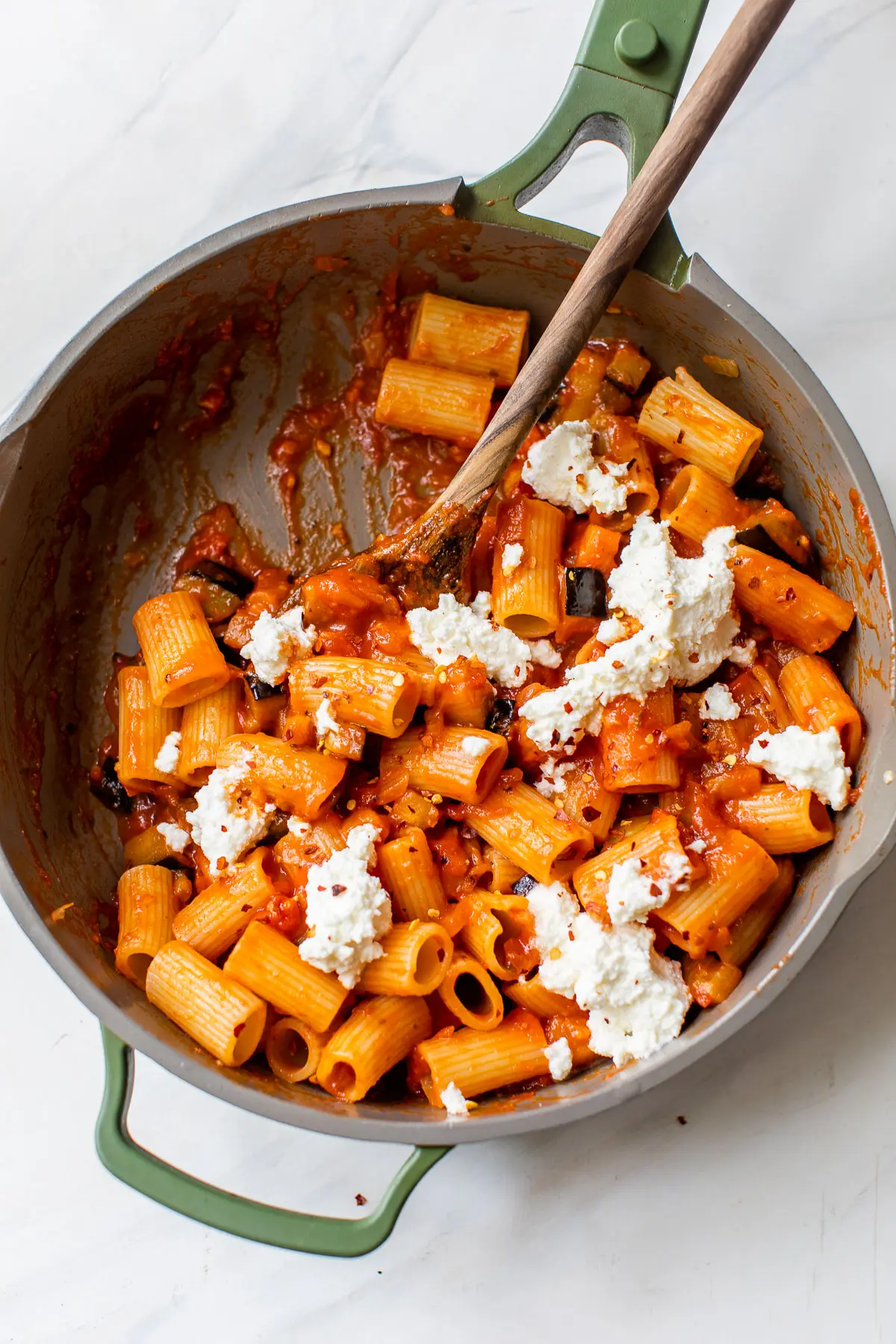 skillet filled with rigatoni pasta and dollops of ricotta cheese