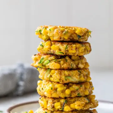 a large stack of fritters on a small white plate