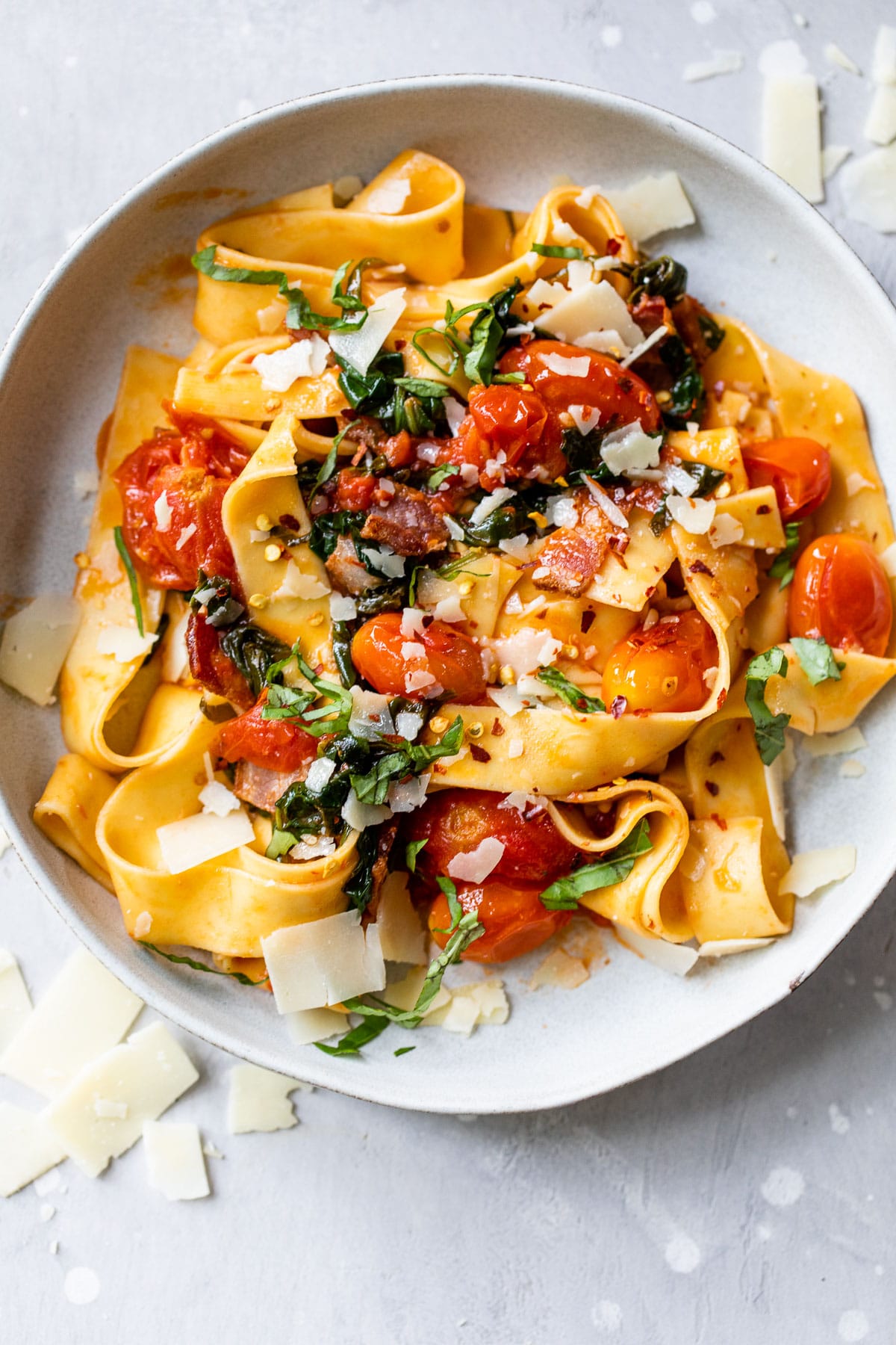 bowl of tomato pasta with garlic, bacon and fresh basil
