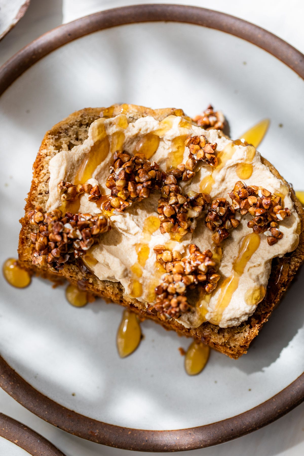 a slice of bread topped with whipped cream and toasted buckwheat