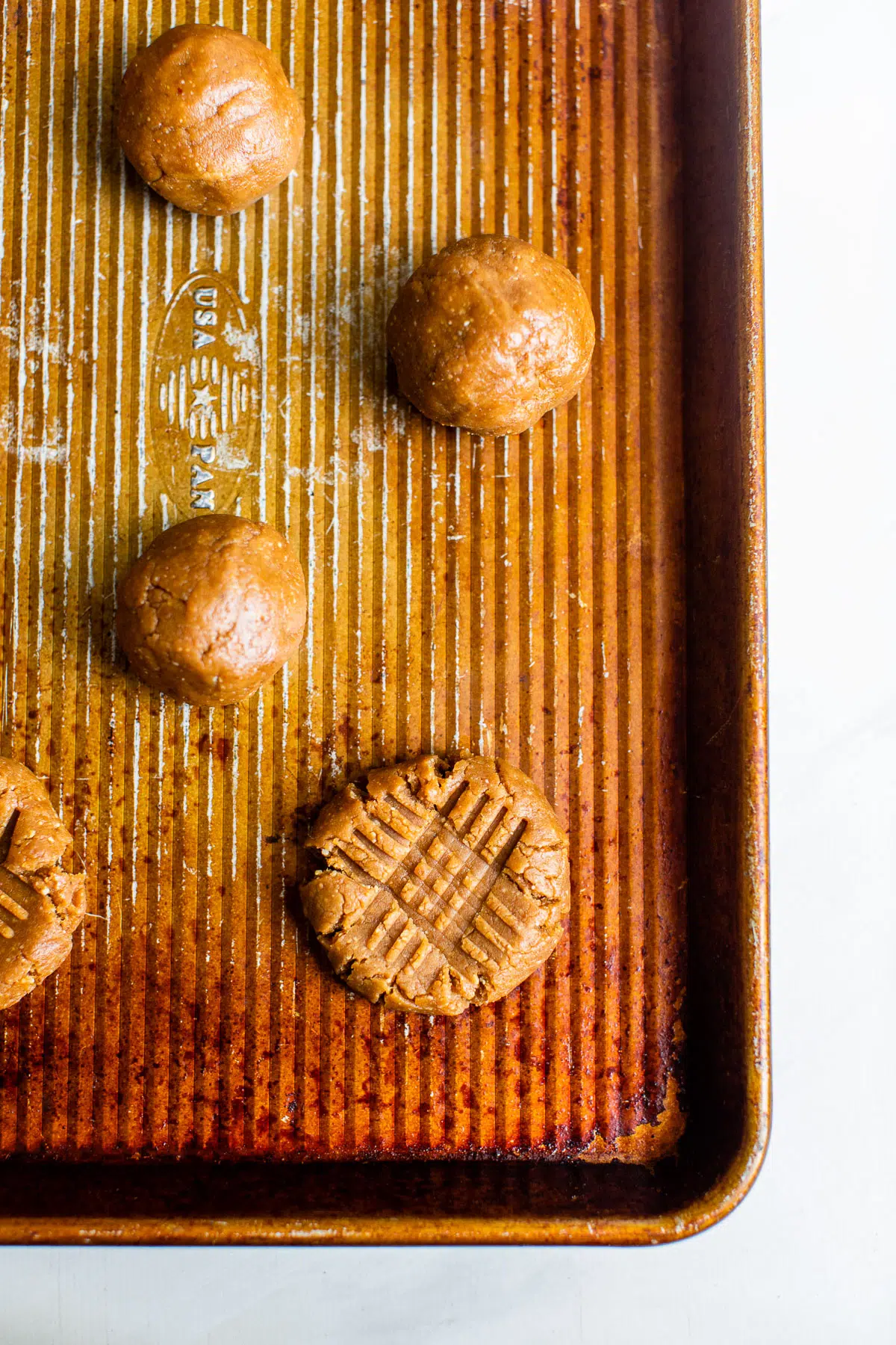 raw peanut butter cookie dough balls on a baking sheet