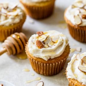 several almond cupcakes on a table topped with sliced almonds
