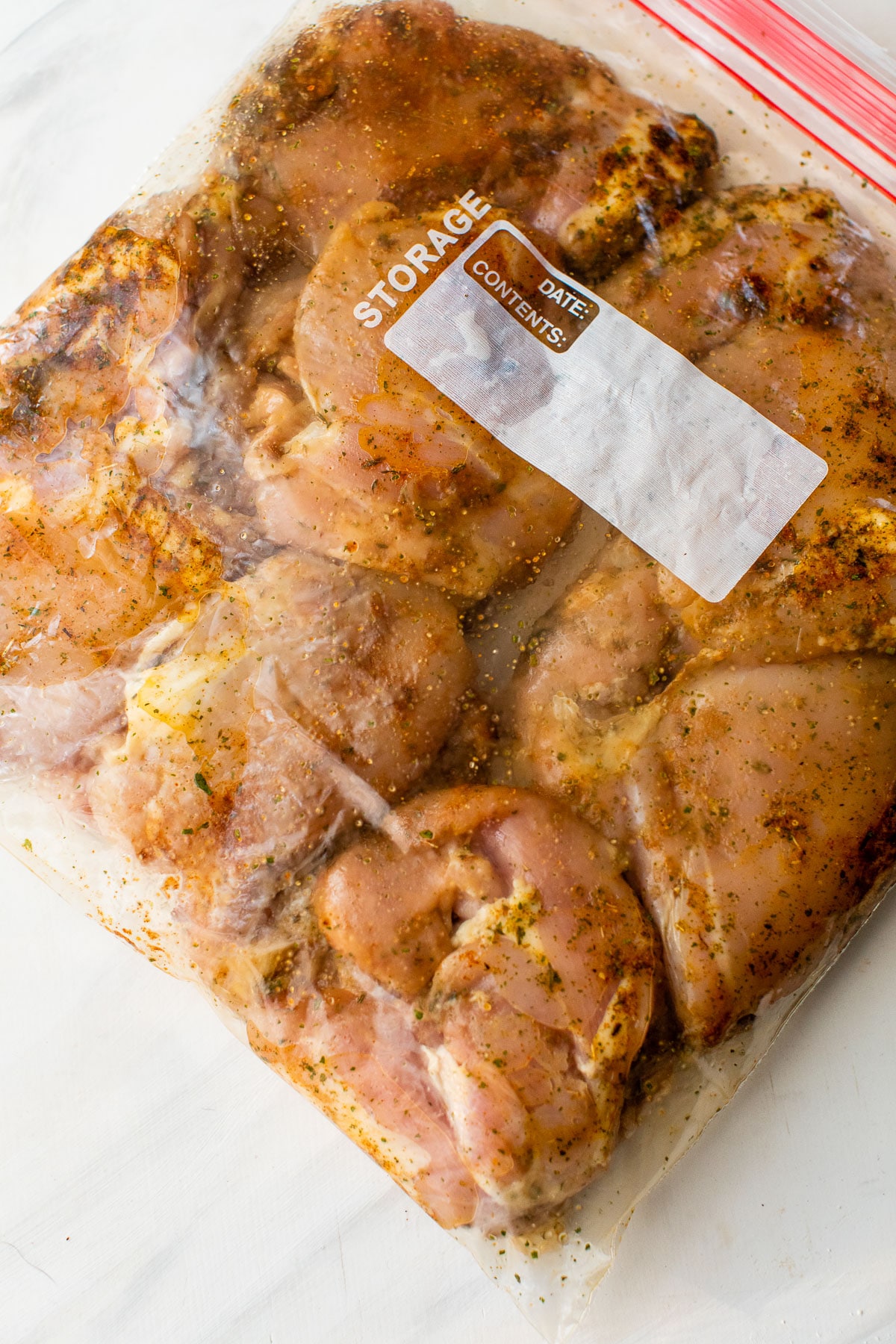raw chicken marinating in spices and herbs