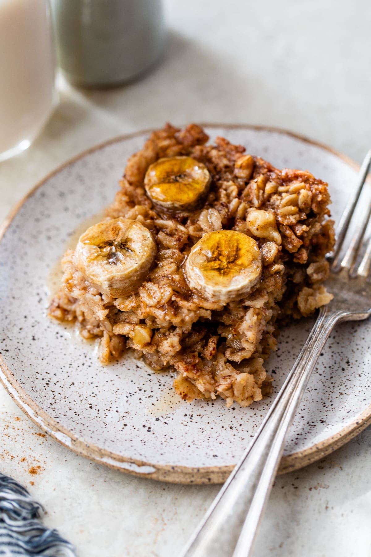 a piece of baked oatmeal on a plate topped with sliced banana