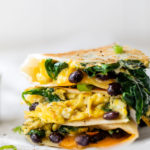 egg and black bean quesadilla stacked on parchment paper